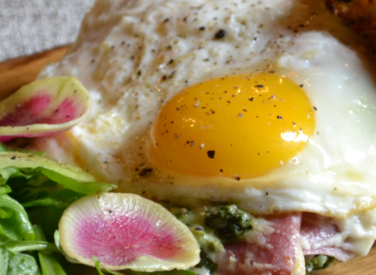 greens, eggs, and meat on a wooden plank