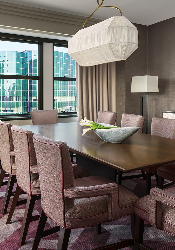brown rectangular table with pink accent chairs