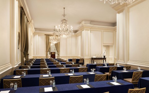 rows of rectangular tables with navy tablecloths