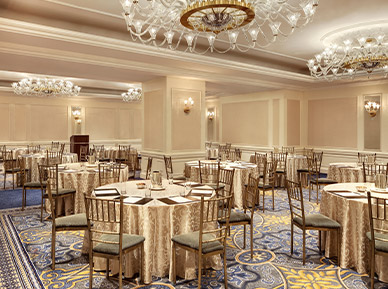 large meetings venue set for a large event with golden colors and a chandelier