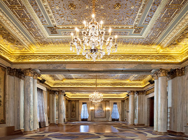 large event space with gold accent walls and a chandelier