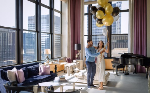 couple celebrating in the penthouse with balloons