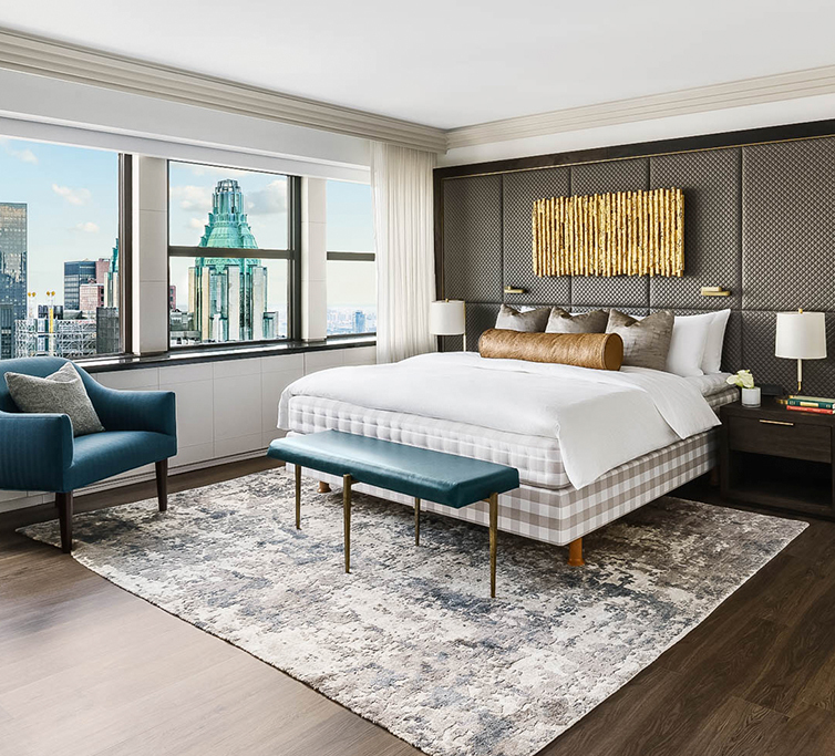bedroom with queen bed and view of city skyline in the background