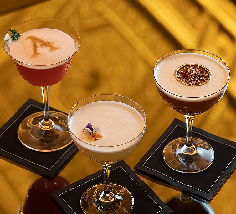 three cocktails with foam art on top