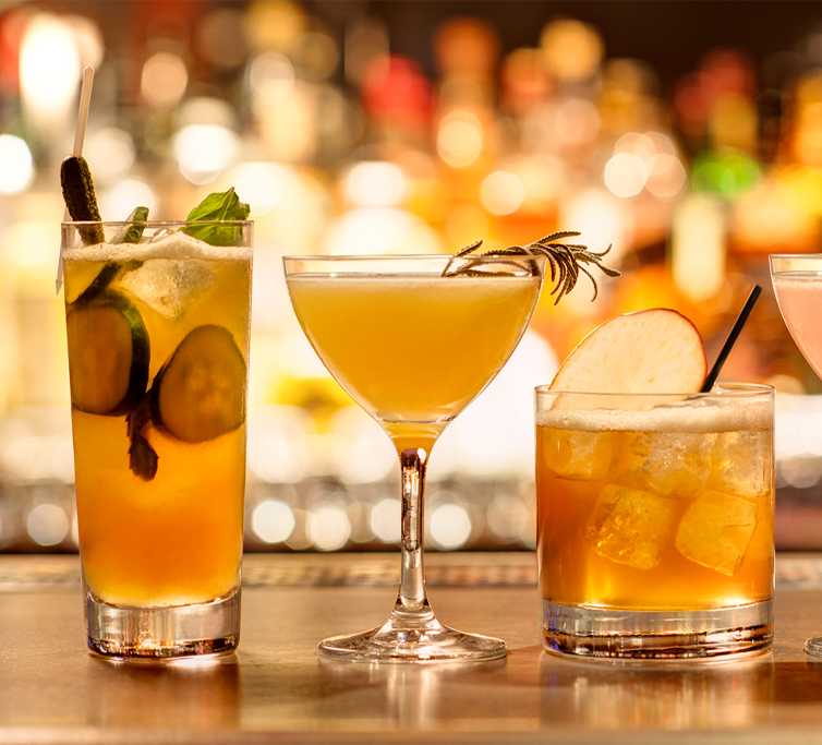 three cocktails with assorted garnishes