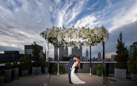 wedding couple posing on the rooftop overlooking the city 