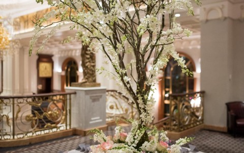 a table of name tags awaits the wedding guests with a floral center piece 