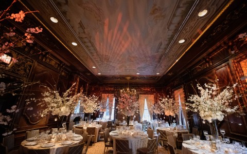 beautiful wedding reception with oak colored walls and white flower center pieces 