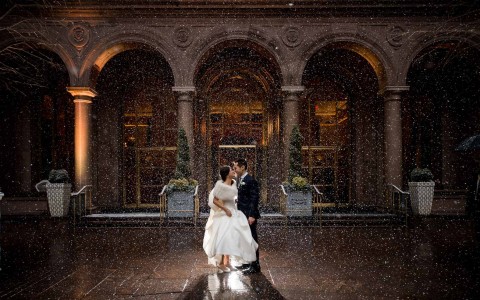 bride and groom kiss in the rain in the courtyard 