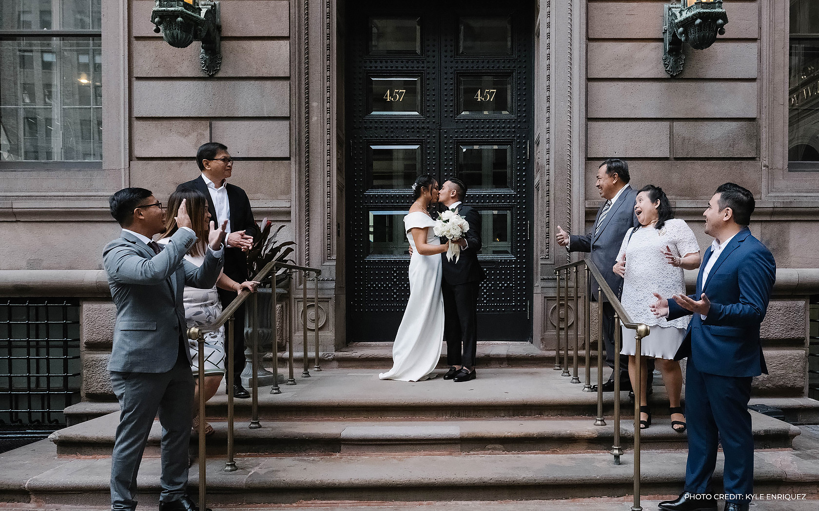 bride and groom kiss in front of their closest family and friends