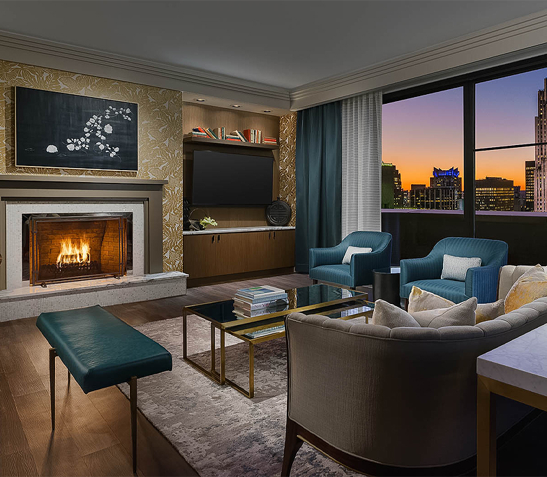 Living area with a fireplace and a beautiful view of the city's sunset 