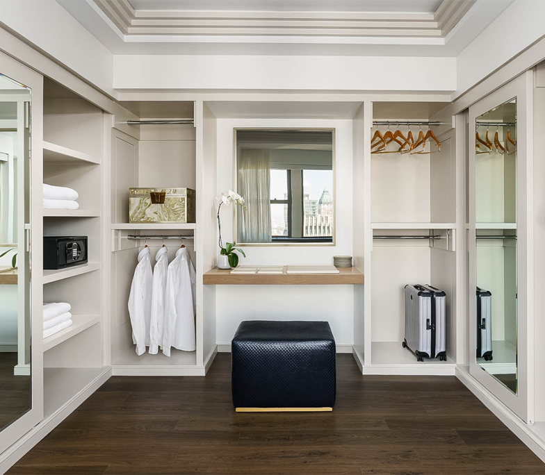 Spacious walk-in closet with ottoman 