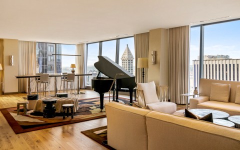 living room area within the suite and a piano in the background