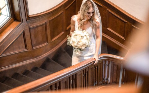 bride looking down the wooden staircases shes on
