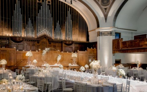 large wedding venue with flower decor and an organ in the background