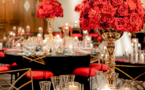 wedding decor on tables with red floral details and black accents