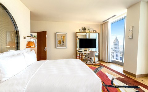 king bed room with city view and large tv in the corner of the room