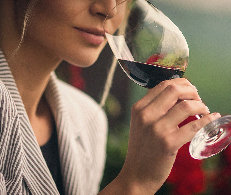 A woman smelling wine