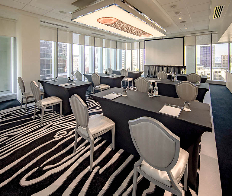 meeting space set up with silver chairs facing a screen