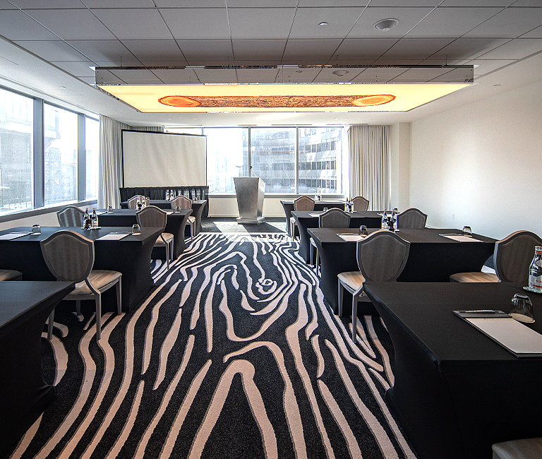 meeting space rooms with tables and chairs set up and a view of the city behind the front of the room