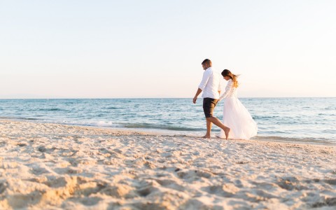 Bride and groom walking down the beach