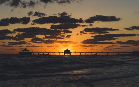 Beach pier with sun setting in the back