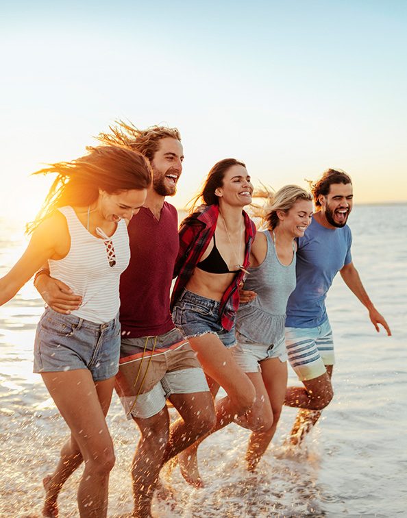 Group of people running towards ocean shore