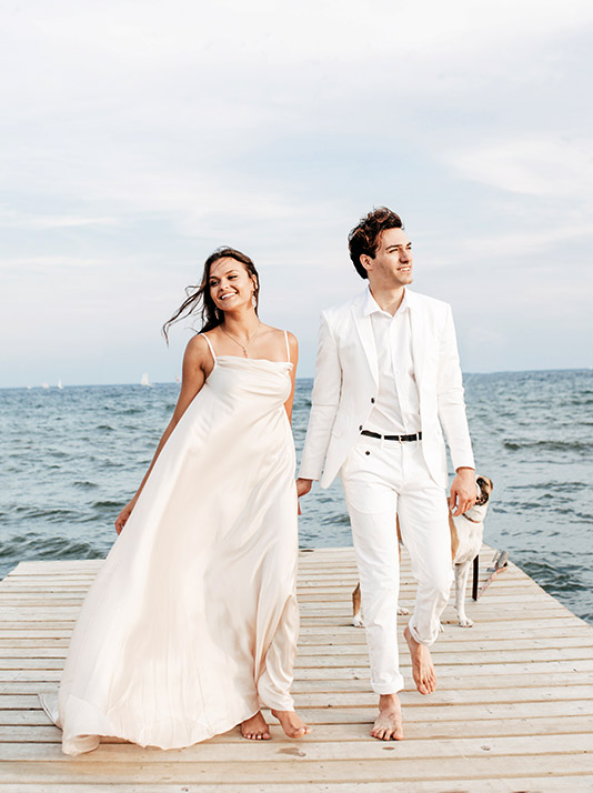 Wedding couple walking on wooden dock