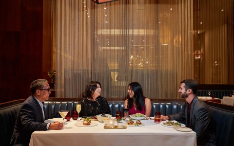 a table of 4 laughing and enjoying dinner