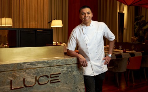 The chef leaning on a desk that says Luce