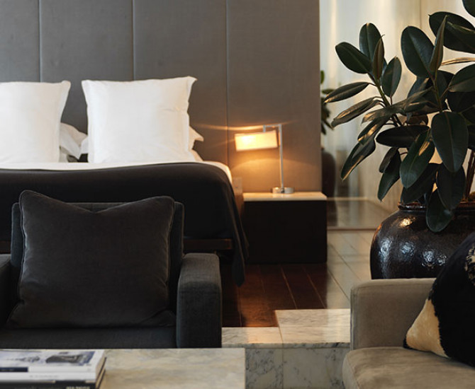 bedroom with black bed and white pillows, a desk and armchair