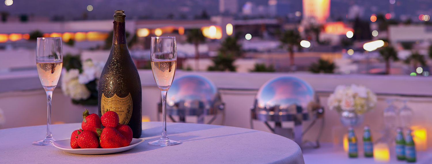 Close up of two glasses of wine with fresh strawberries on table set up on rooftop