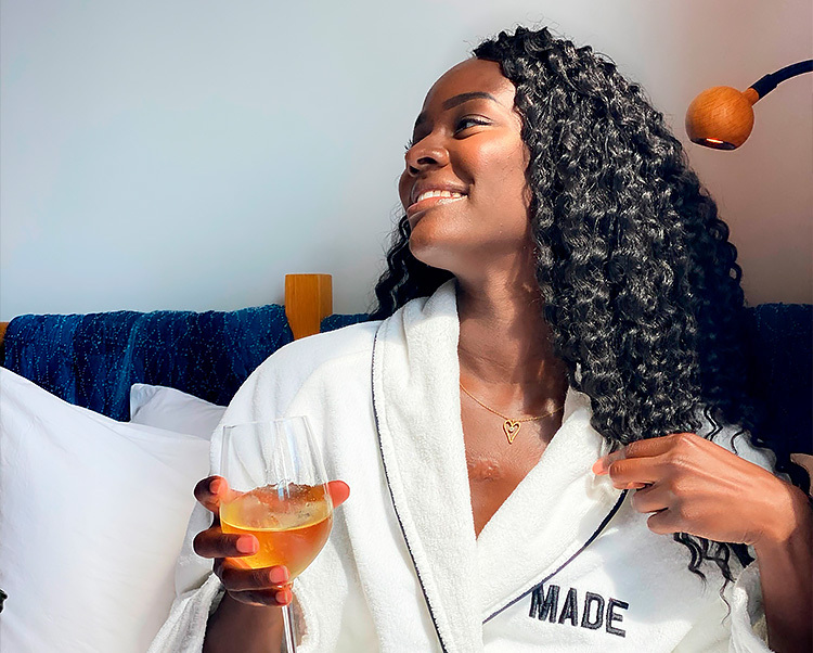 woman holding a cocktail in a comfortable white robe