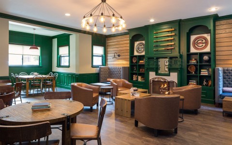 hotel living room with different tables set up and a wall decorated with baseball bats 