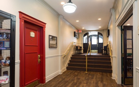 hotel lobby with a door on the left and stairs 