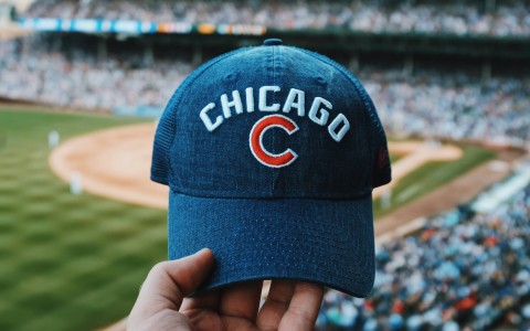 a baseball cap with the word chicago and the baseball field on the background 