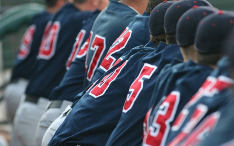 baseball players sitting down and wearing a baseball jersey