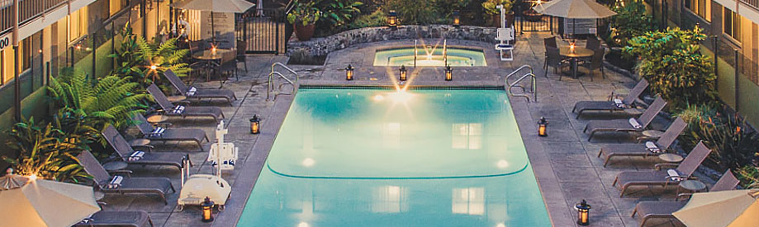 rectangular pool surrounded by brown lounge chairs