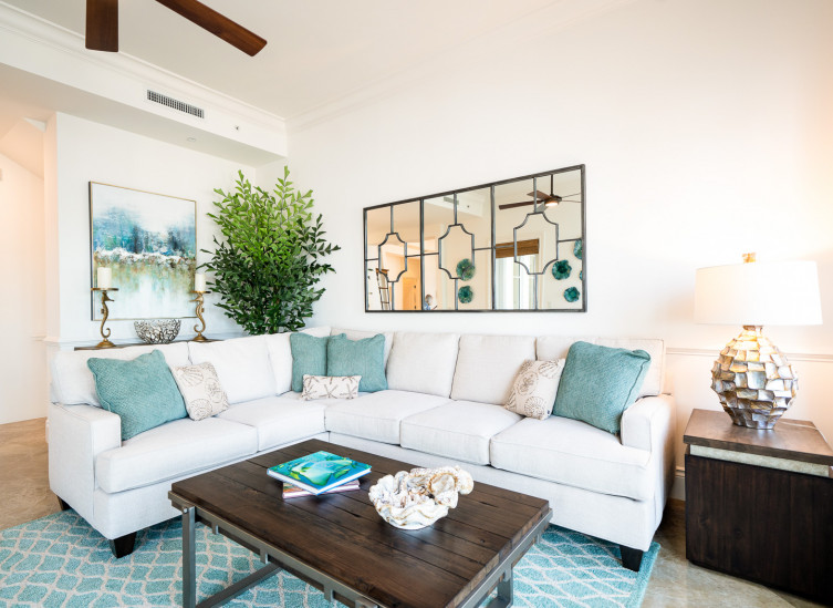 room living space with white sectional, aqua throw pillows & rug
