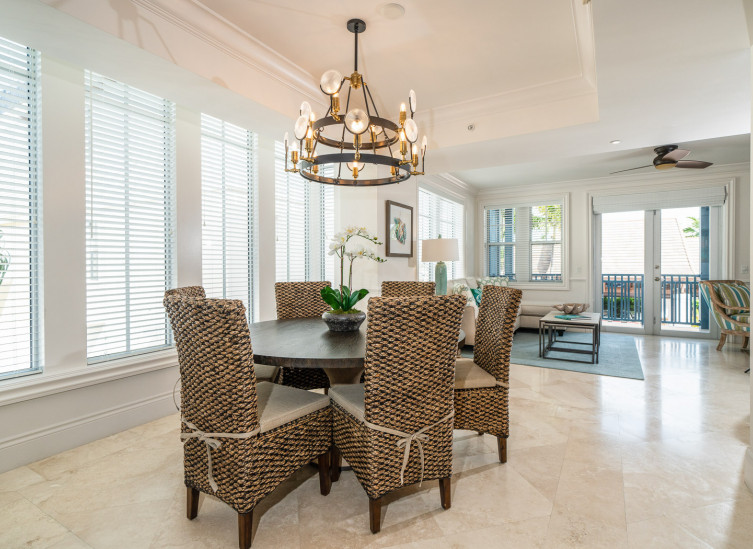 Dining table with wicker chairs next to living area