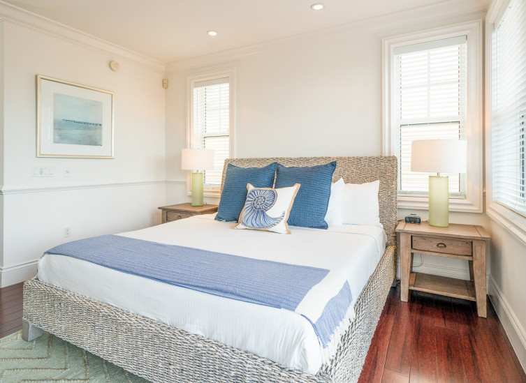 Room with double bed, wicker nighstands & seafoam rug