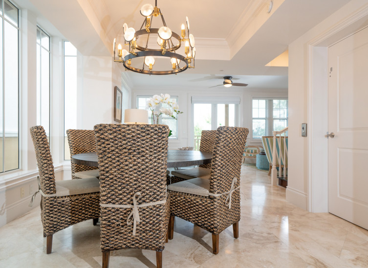 Dining table with wicker chairs under chandelier