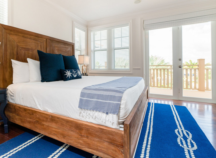 Room with double bed, wooden frame & deep blue rug