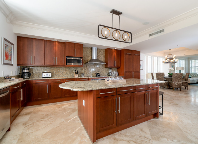 Full kitchen with wooden cabinets, beige countertops & steel appliances