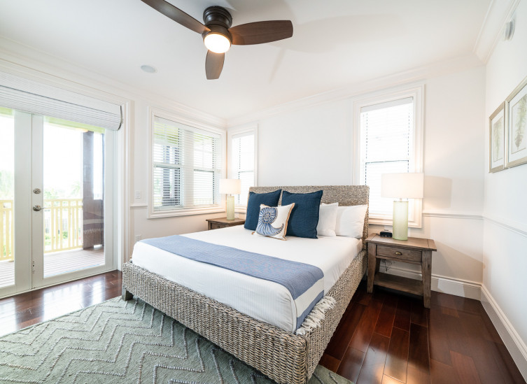 Room with double bed, mint green rug & wicker nightstands