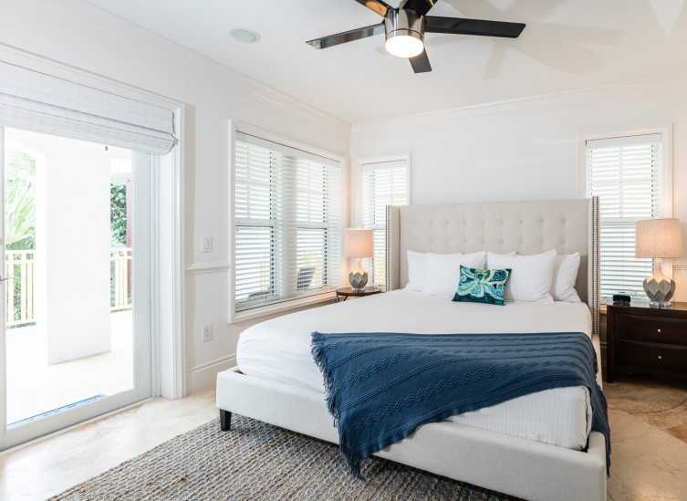 Room with double bed, navy throw blanket & wooden nightstands