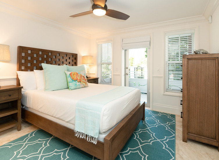 Room with double bed, wooden bed frame & aqua rug
