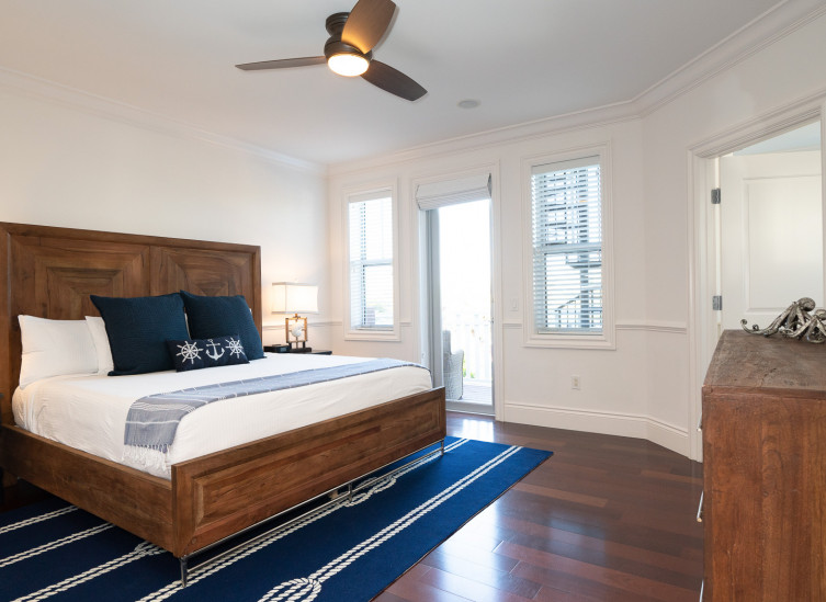 Room with double bed, wooden bed frame & navy blue rug