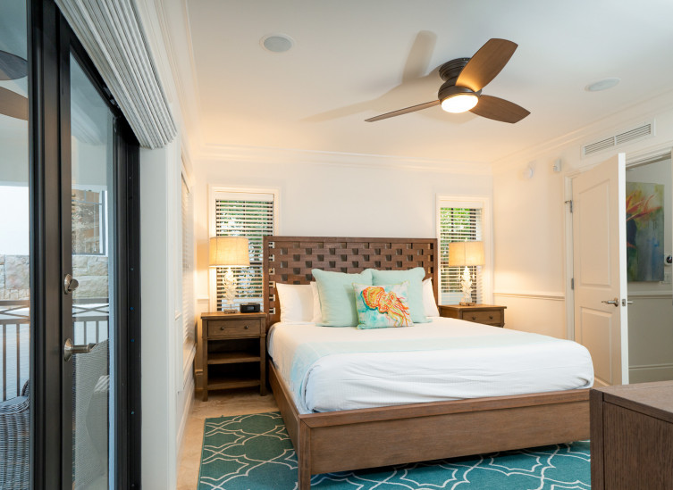 Room with double bed, aqua rug & fish throw pillows