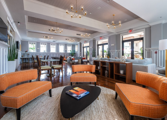 clubhouse with curved orange couches around a table with seating in background
